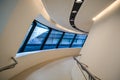 Modern building inside. With slanted and semicircular walls, big windows and balconies, with illumination. Architecture. Geometry.