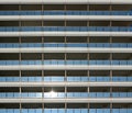 Modern building metal facade with rows of blue glass balconies