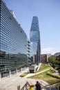 A modern building's green roof and glass facade reflect the surrounding cityscape