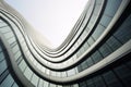 Modern building with wavy futuristic design, low angle view of abstract curve lines and sky. Geometric facade with glass and steel