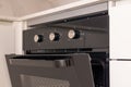 Modern built-in kitchen oven with open door and control knobs Royalty Free Stock Photo