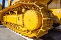 Modern bulldozer tracks and drive gear, large yellow construction machine, heavy industry