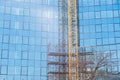 New modern architecture business building construction site with big glass windows facade scaffolds and crane part Royalty Free Stock Photo