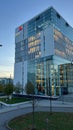 a business building with glass windows, a red phone in the middle of it