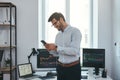 Modern business. Happy and successful trader in formal wear is looking at trading graphs and reports on his smartphone Royalty Free Stock Photo