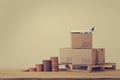 Modern business, online shopping concept : Arrange step coin and cardboard boxes for packing of goods with plane on wood pallet. Royalty Free Stock Photo