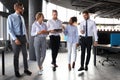 Modern business people discussing business and smiling while walking through the office corridor Royalty Free Stock Photo