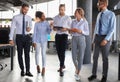 Modern business people discussing business and smiling while walking through the office corridor Royalty Free Stock Photo