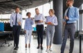 Modern business people discussing business and smiling while walking through the office corridor Royalty Free Stock Photo