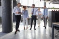 Modern business people discussing business and smiling while walking through the office corridor Royalty Free Stock Photo