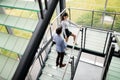 Modern business people walking on stairs in glass hall in office building Royalty Free Stock Photo