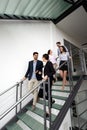 Modern business people walking on stairs in glass hall in office building Royalty Free Stock Photo