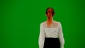 Portrait of attractive office girl on chroma key green screen. Woman in skirt and blouse walking cutely. Back view.