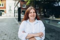 Modern business woman standing near Office Building. Crossed arms. Huge blurred office windows on the background. High Royalty Free Stock Photo