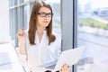 Modern business woman typing on laptop computer while standing in the office before meeting or presentation Royalty Free Stock Photo