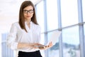 Modern business woman typing on laptop computer while standing in the office before meeting or presentation Royalty Free Stock Photo