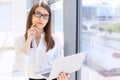 Modern business woman typing on laptop computer while standing in the office before meeting or presentation Royalty Free Stock Photo