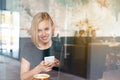 Modern business woman working on smart phone and laptop computer at coffee shop interior near the window Royalty Free Stock Photo