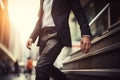 A modern businessman climbs stairs in the bustling city, hurrying to work Royalty Free Stock Photo