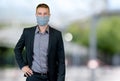 Modern businessman with face mask outdoor in city