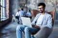 Modern businessman with a laptop sitting in a stylish comfortable chair. Royalty Free Stock Photo