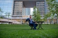 Modern businessman using gadget on coffee break. Business man working at desk in park near office building. Royalty Free Stock Photo