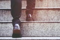 Modern businessman working close-up legs walking up the stairs in modern city. Royalty Free Stock Photo