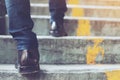 Modern businessman working close-up legs walking up the stairs in modern city.