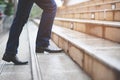 Modern businessman working close-up legs walking up the stairs in modern city. Royalty Free Stock Photo