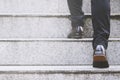 Modern businessman working close-up legs walking up the stairs in modern city. Royalty Free Stock Photo