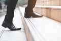 Modern businessman working close-up legs walking up the stairs in modern city. Royalty Free Stock Photo