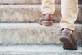 Modern businessman working close-up legs walking up the stairs in modern city. Royalty Free Stock Photo