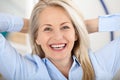 Modern businesswoman. Beautiful middle aged woman looking at camera with smile while siting in the office.