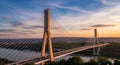 Modern Cable-Stayed Bridge Spans River at Sunset with Dramatic Sky Royalty Free Stock Photo