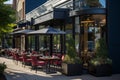 Modern cafe exterior with red chairs and dark umbrellas. Royalty Free Stock Photo