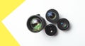 Modern camera lenses with reflections, white yellow background