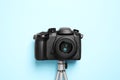 Modern camera with mini tripod on light blue background, flat lay. Video production equipment Royalty Free Stock Photo