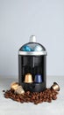 Modern capsule coffee machine with coffee beans and colorful pods on a light surface Royalty Free Stock Photo