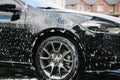 Modern car covered by foam. Car wash. Royalty Free Stock Photo