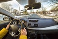 Modern car interior with driver female hands on steering wheel, winter snowy landscape outside. Safe driving concept Royalty Free Stock Photo