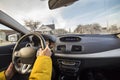 Modern car interior with driver female hands on steering wheel, winter snowy landscape outside. Safe driving concept Royalty Free Stock Photo