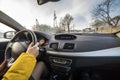 Modern car interior with driver female hands on steering wheel, winter snowy landscape outside. Safe driving concept Royalty Free Stock Photo