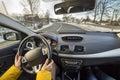 Modern car interior with driver female hands on steering wheel, winter snowy landscape outside. Safe driving concept Royalty Free Stock Photo