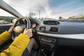 Modern car interior with driver female hands on steering wheel, winter snowy landscape outside. Safe driving concept Royalty Free Stock Photo