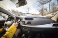 Modern car interior with driver female hands on steering wheel, winter snowy landscape outside. Safe driving concept Royalty Free Stock Photo