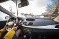 Modern car interior with driver female hands on steering wheel, winter snowy landscape outside. Safe driving concept Royalty Free Stock Photo