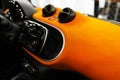 Modern car interior. Part of leather car seat details with stitching. Interior with dashboard. Orange perforated leather. Car deta