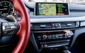 Modern car interior, red steering wheel with media phone control buttons, navigation, screen multimedia system background