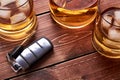 Modern car keys on wooden table top in bar. Glass and bottle of whiskey or other alcohol with ice. for the article on drunk