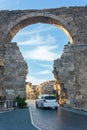 Car passes through the ancient Vespasian Gate in Side, Turkey Royalty Free Stock Photo